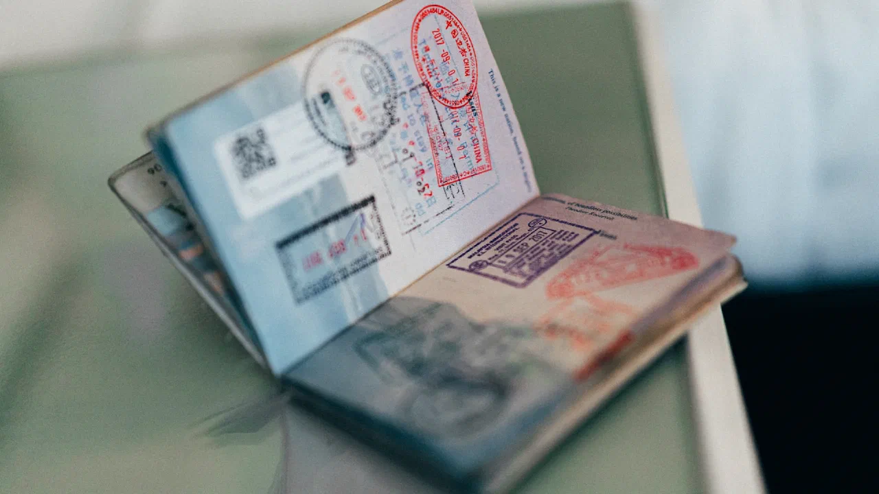 an open passport with ink entry stamps across two pages