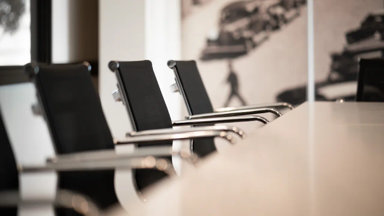 black office chairs lined up along a conference table