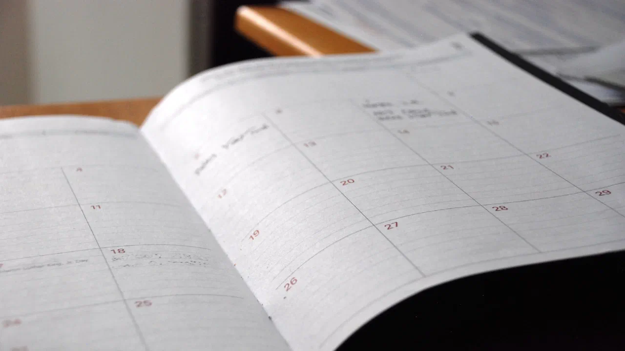 an open monthly planner on a wooden desk
