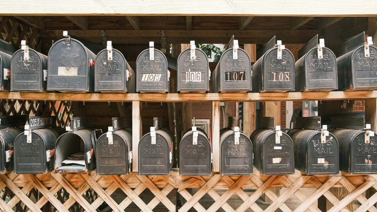 Rows of old black metal mailboxes in a building entrance