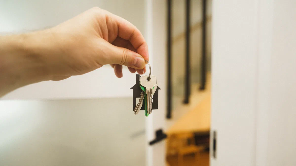 a hand holding a key in front of an open door